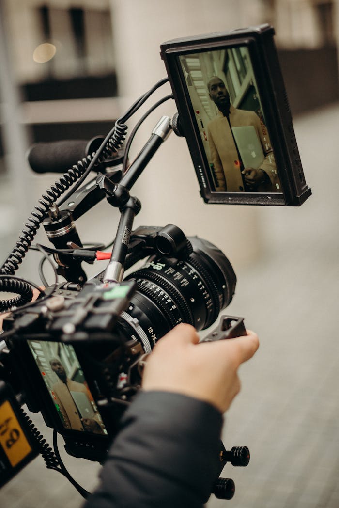 A videographer adjusts high-end filming equipment during an outdoor video production.